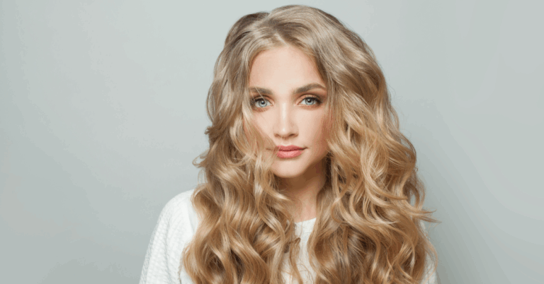 Woman with long wavy blonde hair extensions styled in loose curls.